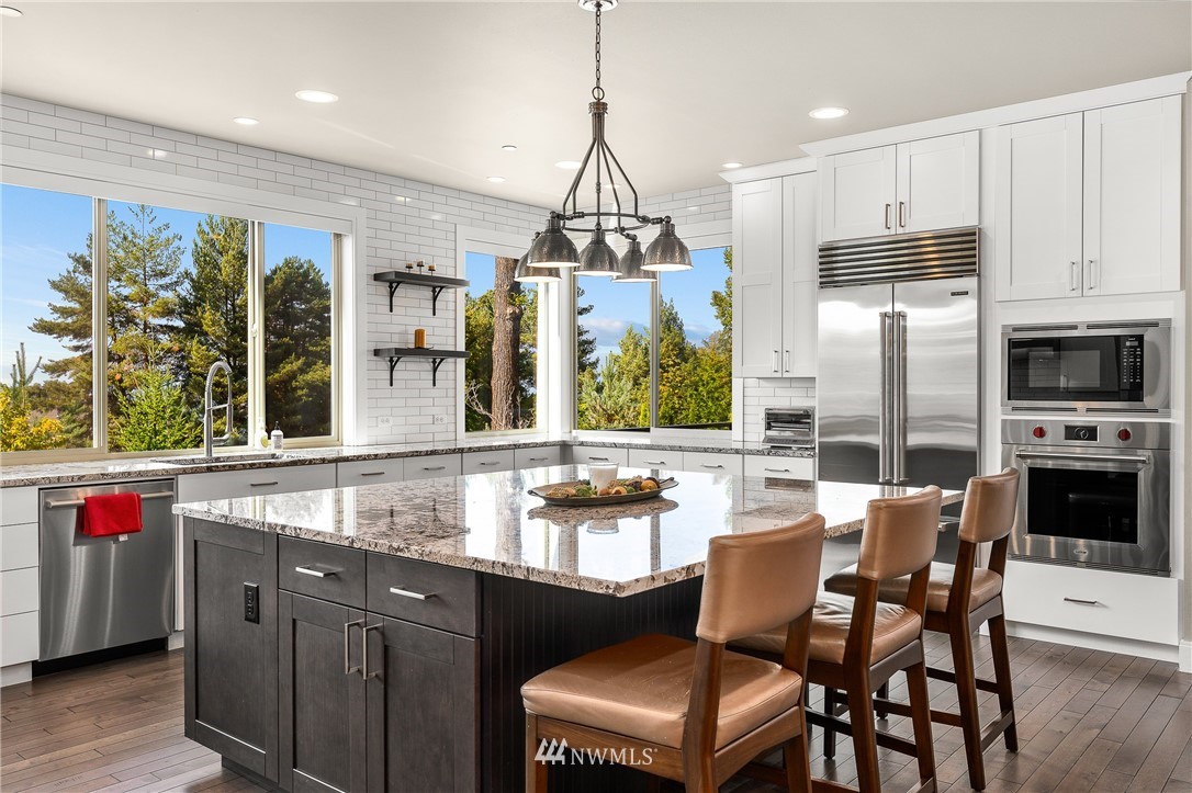 10406 Northeast 52nd Street Kirkland, WA 98033 - Photo 13 of 36 a kitchen with stainless steel appliances granite countertop a kitchen island hardwood floor and a view of living room