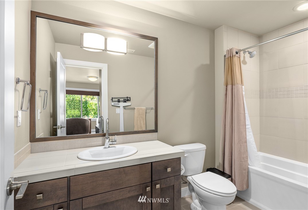 10406 Northeast 52nd Street Kirkland, WA 98033 - Photo 23 of 36 a bathroom with a sink a toilet a mirror and shower