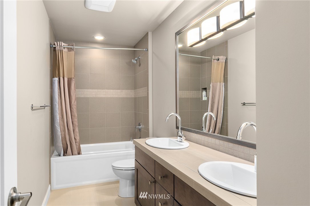 10406 Northeast 52nd Street Kirkland, WA 98033 - Photo 25 of 36 a bathroom with a sink toilet a mirror and shower