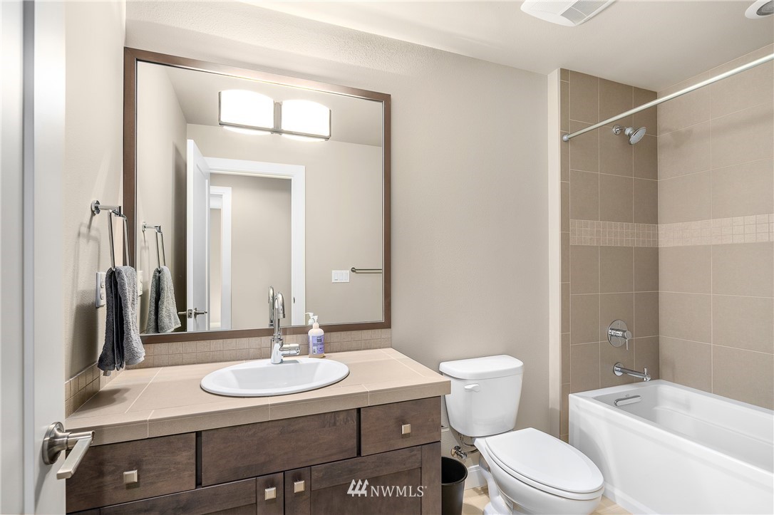 10406 Northeast 52nd Street Kirkland, WA 98033 - Photo 28 of 36 a bathroom with a sink a toilet a mirror and shower