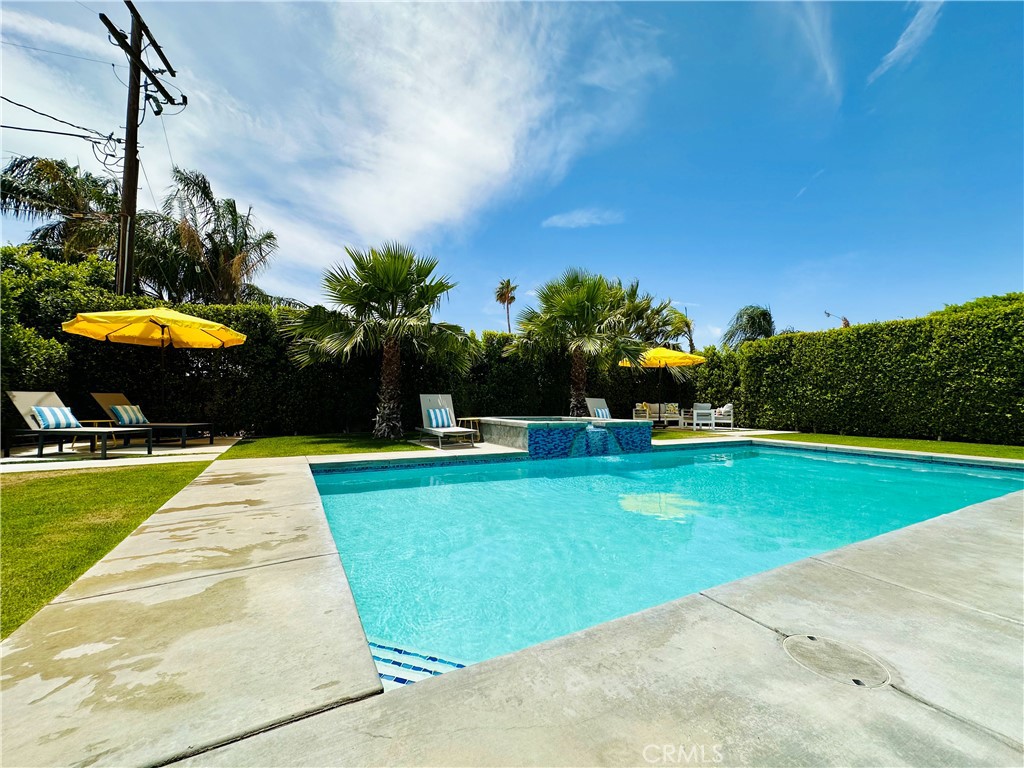 68315 Modalo Road Cathedral City, CA 92234 - Photo 18 of 18 a view of a swimming pool with a yard and palm trees
