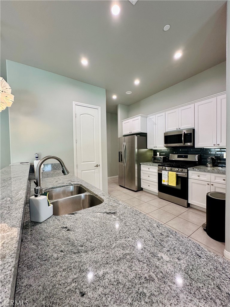 68315 Modalo Road Cathedral City, CA 92234 - Photo 4 of 18 a kitchen with stainless steel appliances granite countertop a sink a stove and a refrigerator