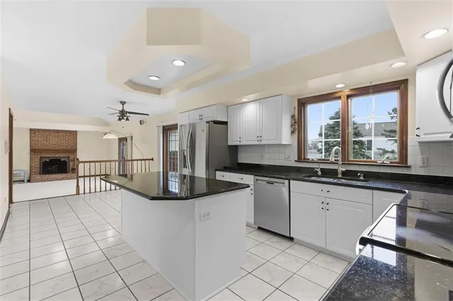a kitchen with stainless steel appliances granite countertop a stove a sink and a refrigerator