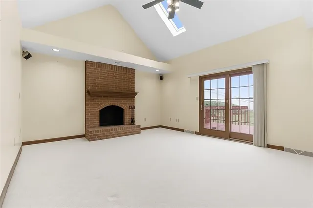 an empty room with fireplace and windows