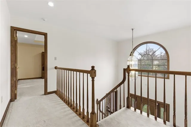 a view of staircase with railing and a chandelier