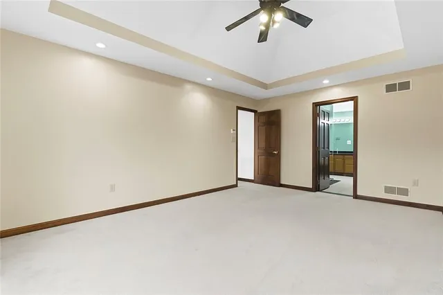 an empty room with chandelier fan