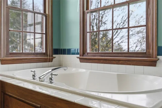 a bathroom with a bathtub and next to a window