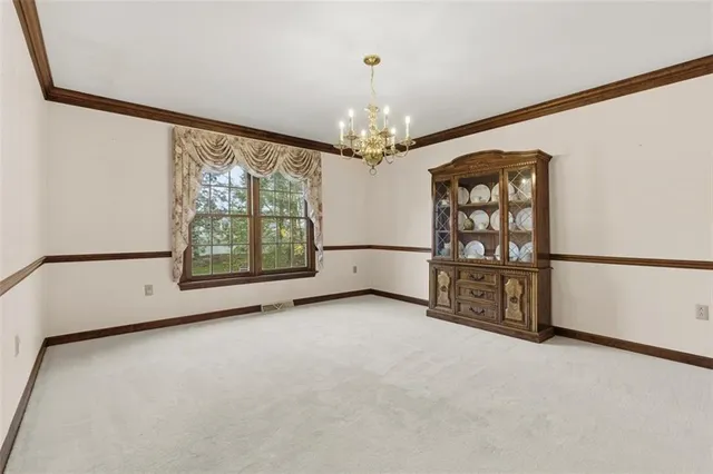 an empty room with windows and chandelier