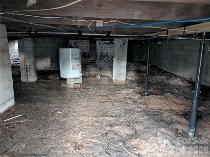 a room with water heater and a wooden cabinet