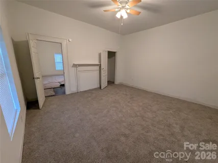 a view of a room with a ceiling fan and a window