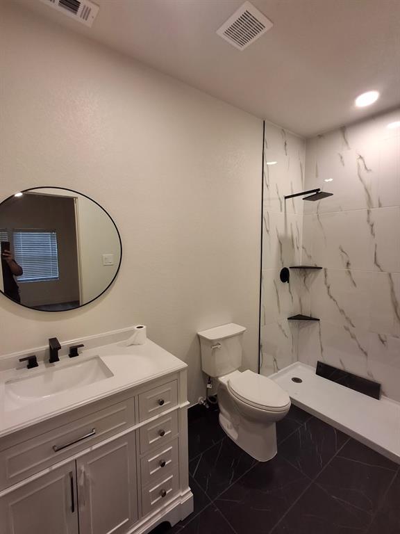 902 Chestnut Street Commerce, TX 75428 - Photo 11 of 18 a bathroom with a double vanity sink toilet and a mirror