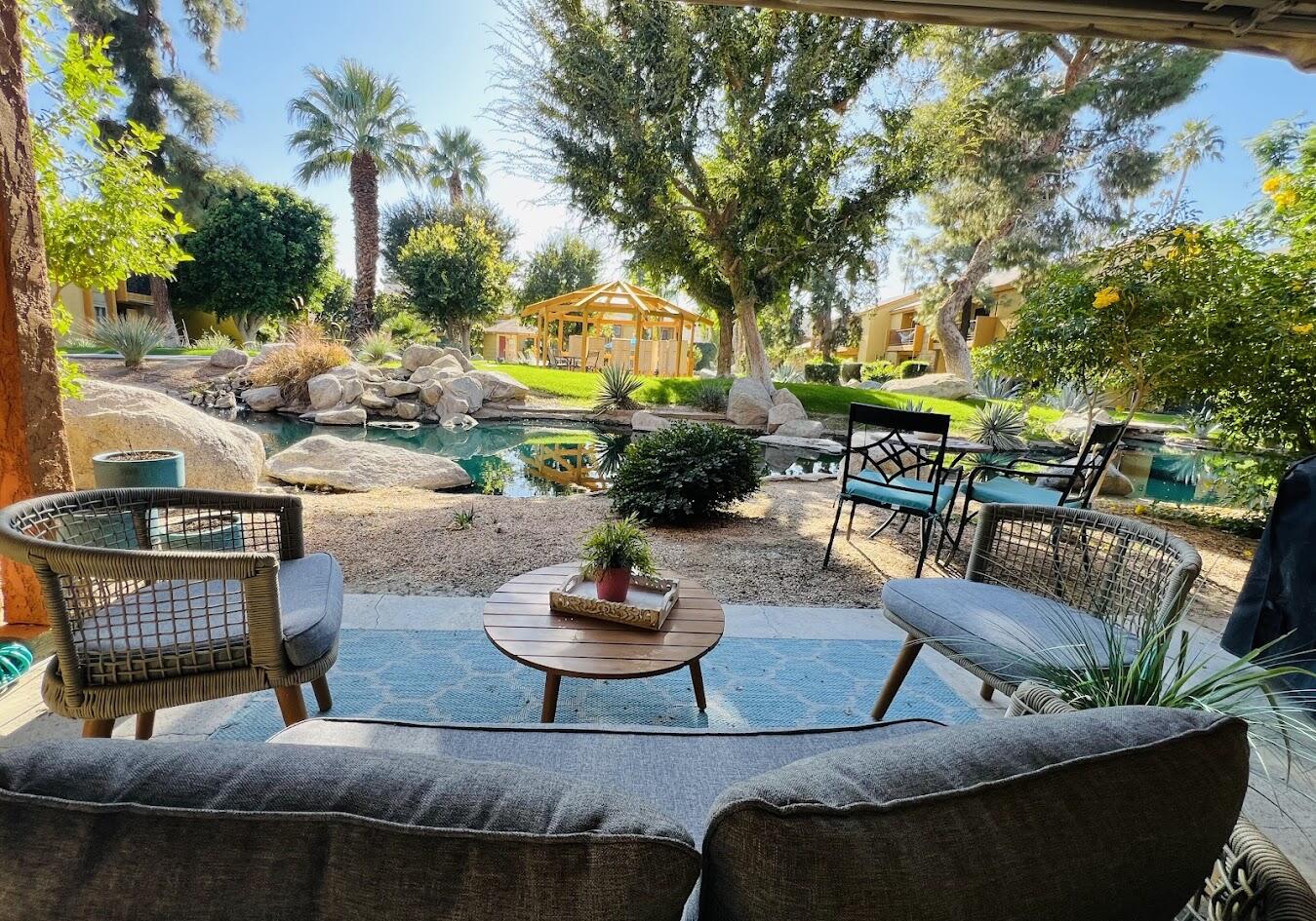 a view of a patio with couches table and chairs and potted plants
