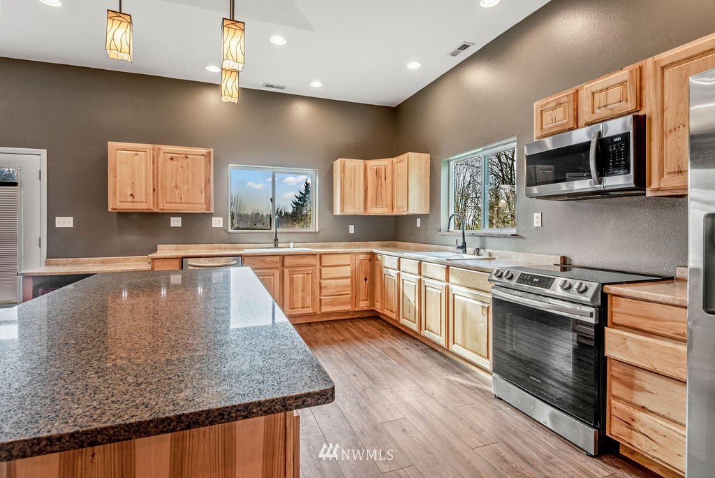 195 Puma Road Longview, WA 98632 - Photo 8 of 39 a kitchen with stainless steel appliances granite countertop a sink a stove and microwave