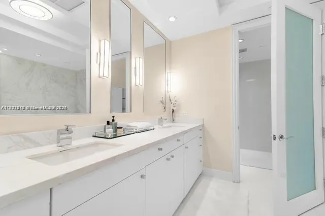 a bathroom with double sink and a mirror