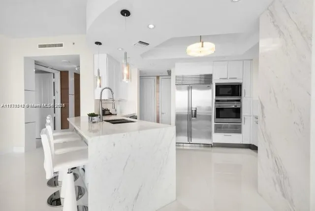 a large kitchen with a large counter top appliances and cabinets