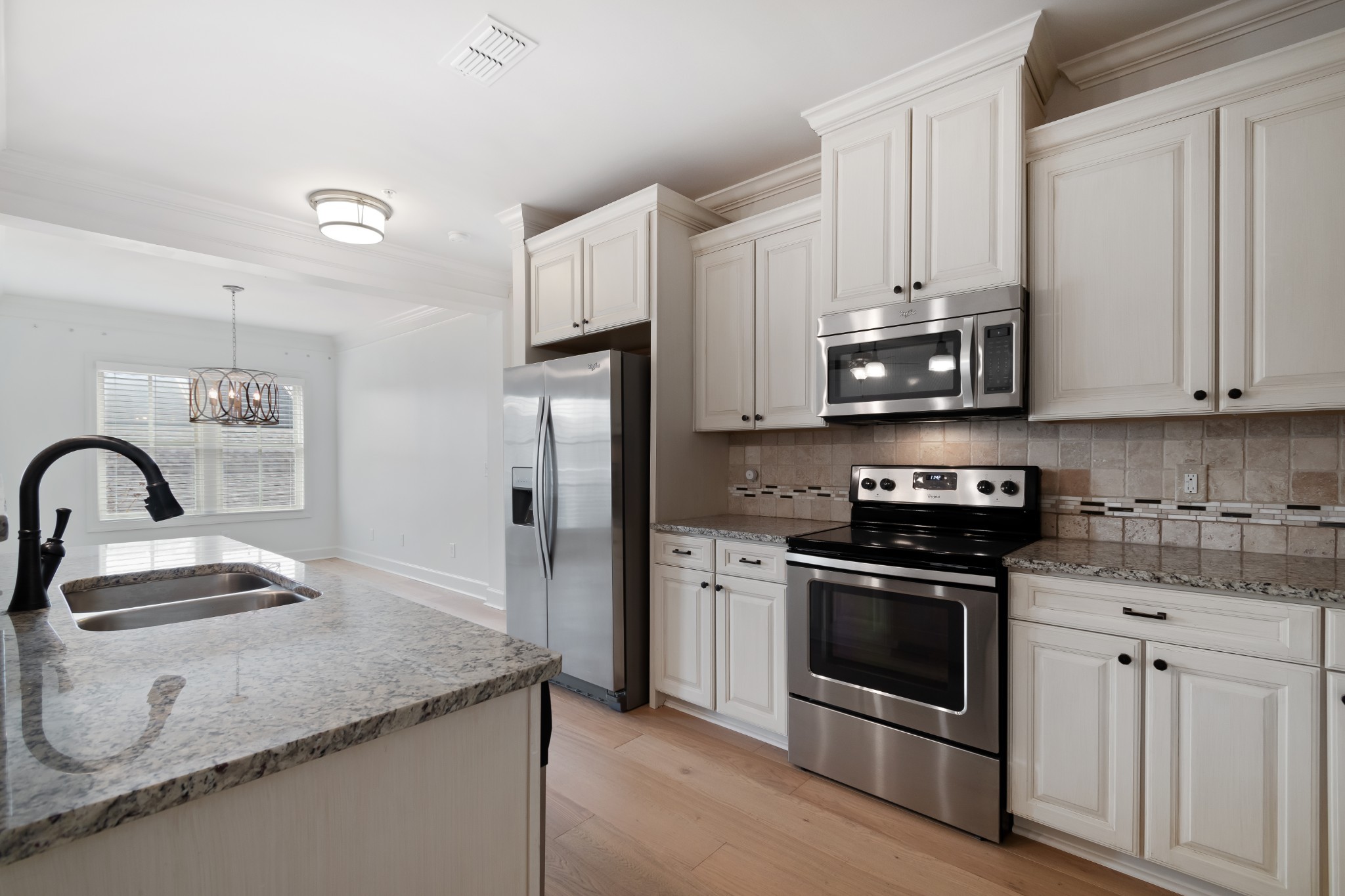 106 Front Street, Unit 23 Franklin, TN 37064 - Photo 26 of 39 a kitchen with stainless steel appliances granite countertop a stove a refrigerator and a sink