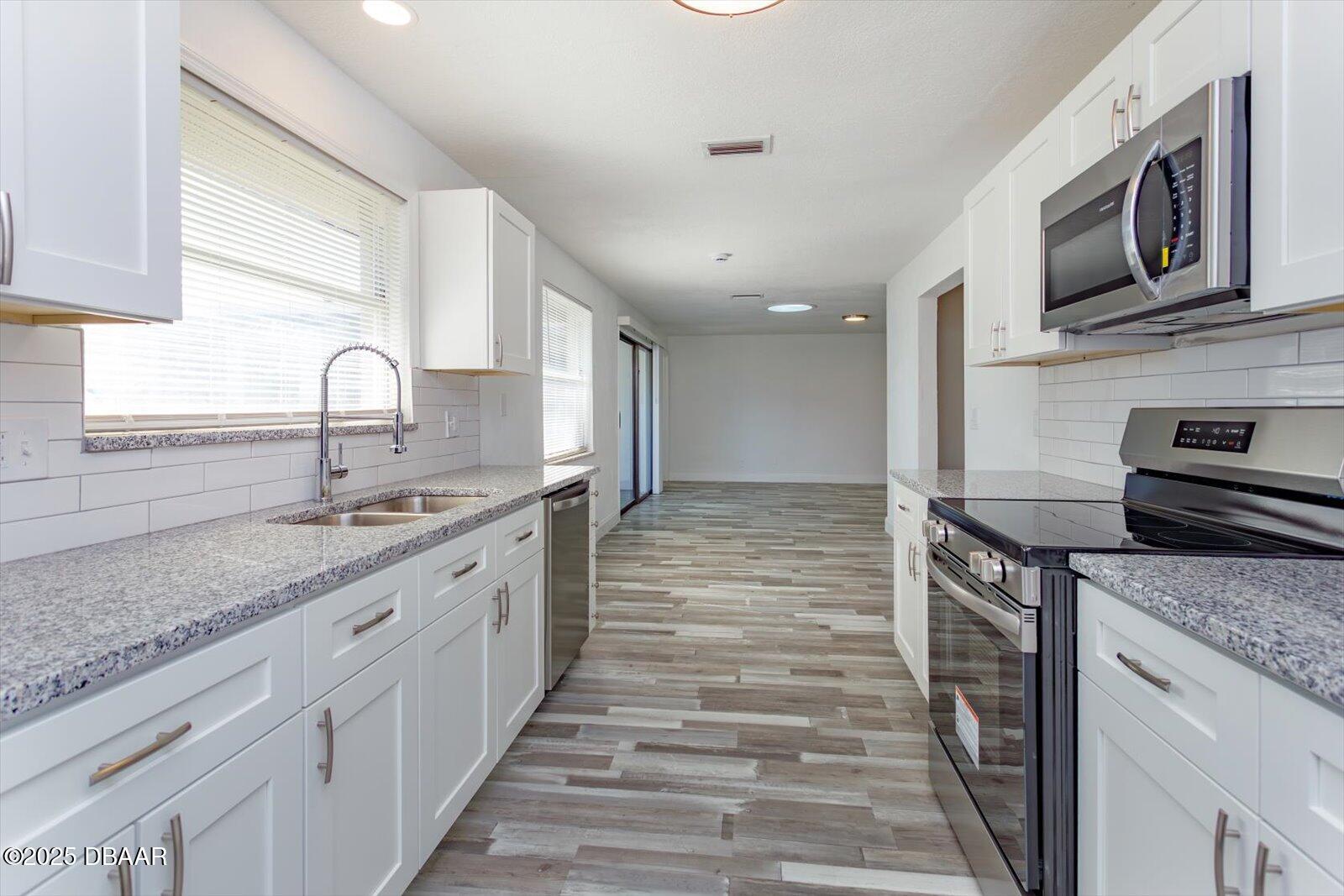 4319 South Peninsula Drive Ponce Inlet, FL 32127 - Photo 16 of 30 a kitchen with stainless steel appliances granite countertop a stove and a sink