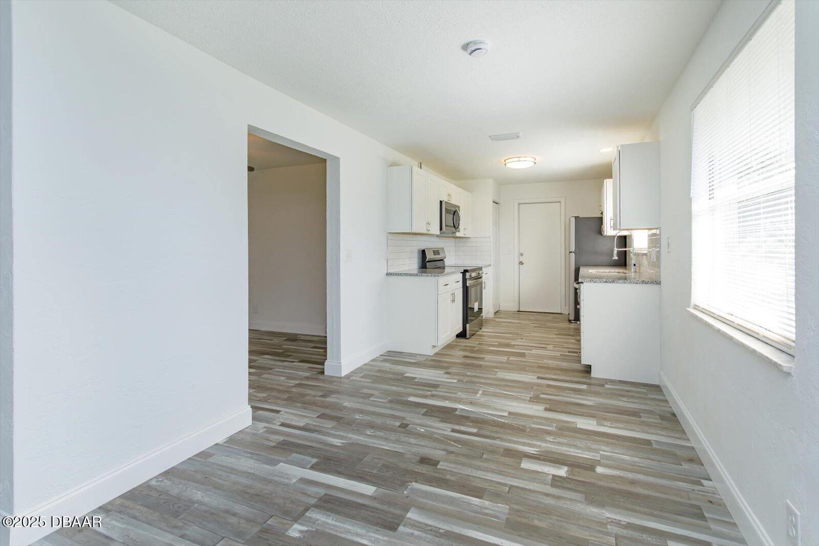 4319 South Peninsula Drive Ponce Inlet, FL 32127 - Photo 17 of 30 a view of a kitchen with wooden floor and a refrigerator