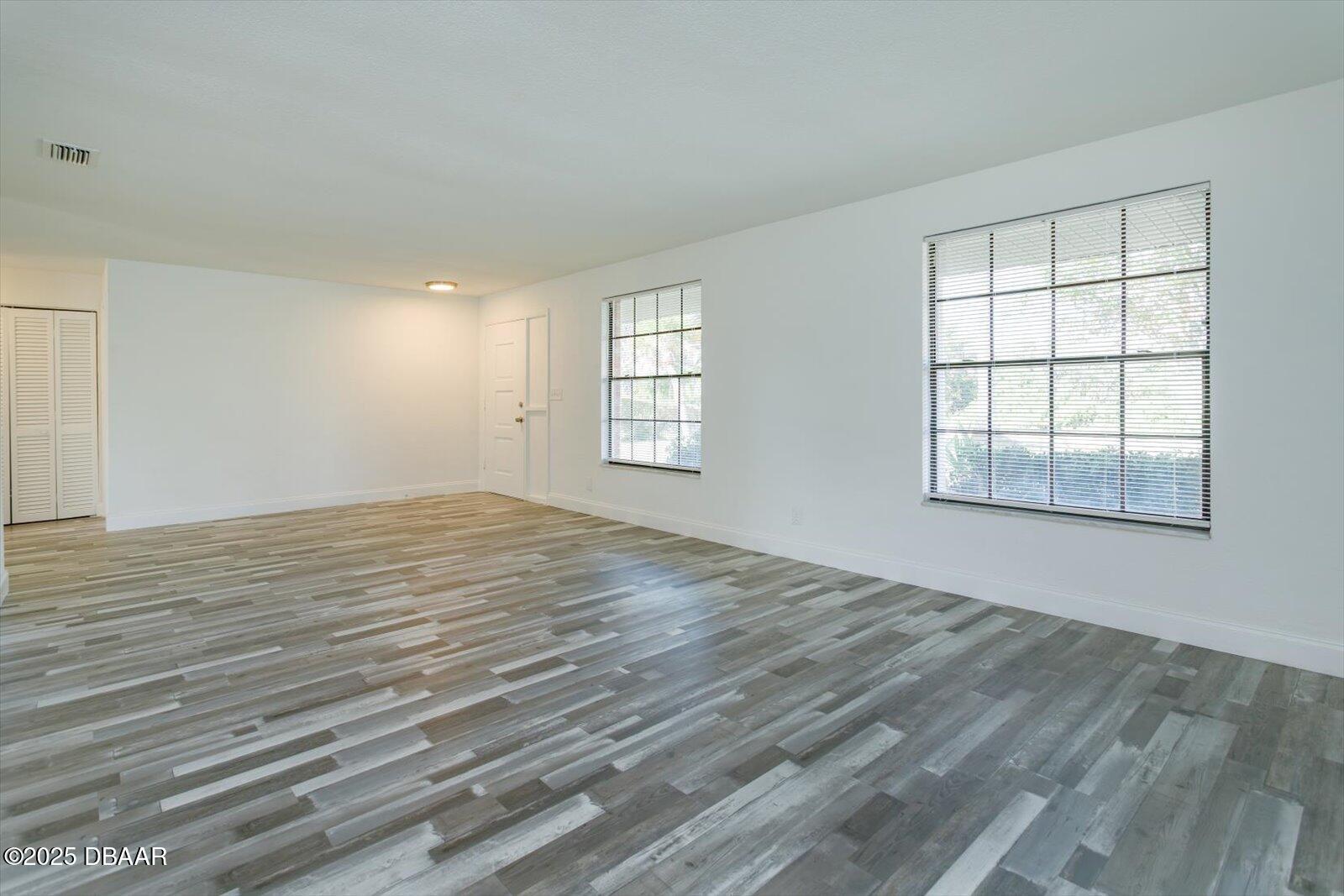 4319 South Peninsula Drive Ponce Inlet, FL 32127 - Photo 10 of 30 an empty room with wooden floor and windows