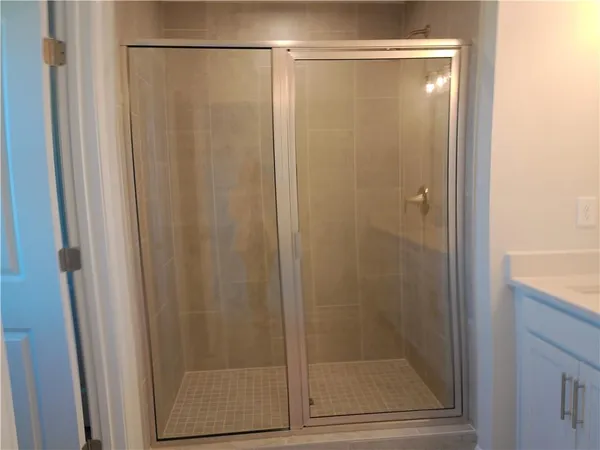 a bathroom with a glass shower door