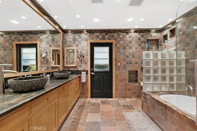 a dining room with stainless steel appliances granite countertop a table chairs and a chandelier