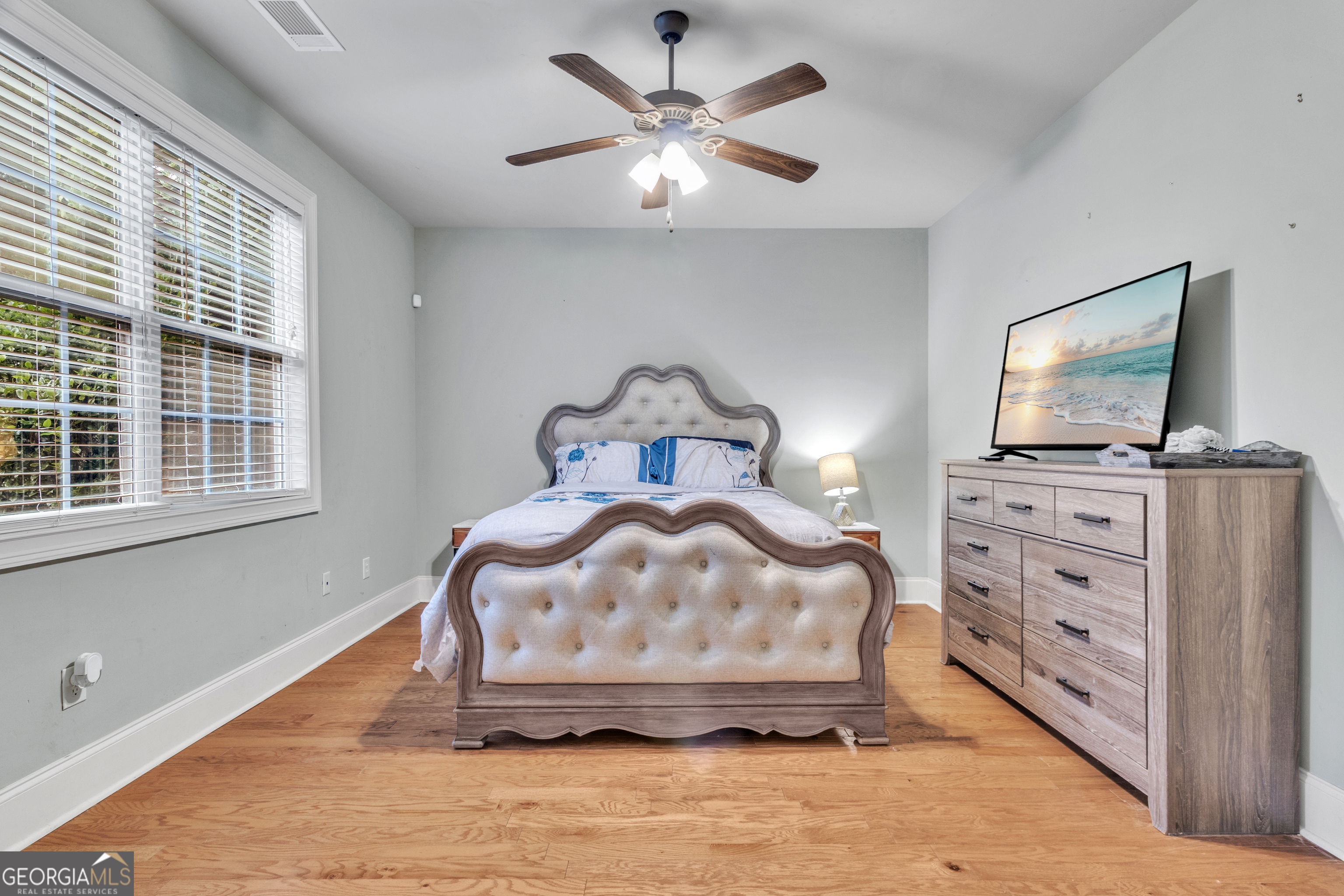 111 Caraway Road Locust Grove, GA 30248 - Photo 31 of 52 a bedroom with a bed and a flat tv screen on dresser