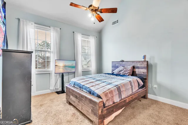 a spacious bedroom with a large bed and a chandelier