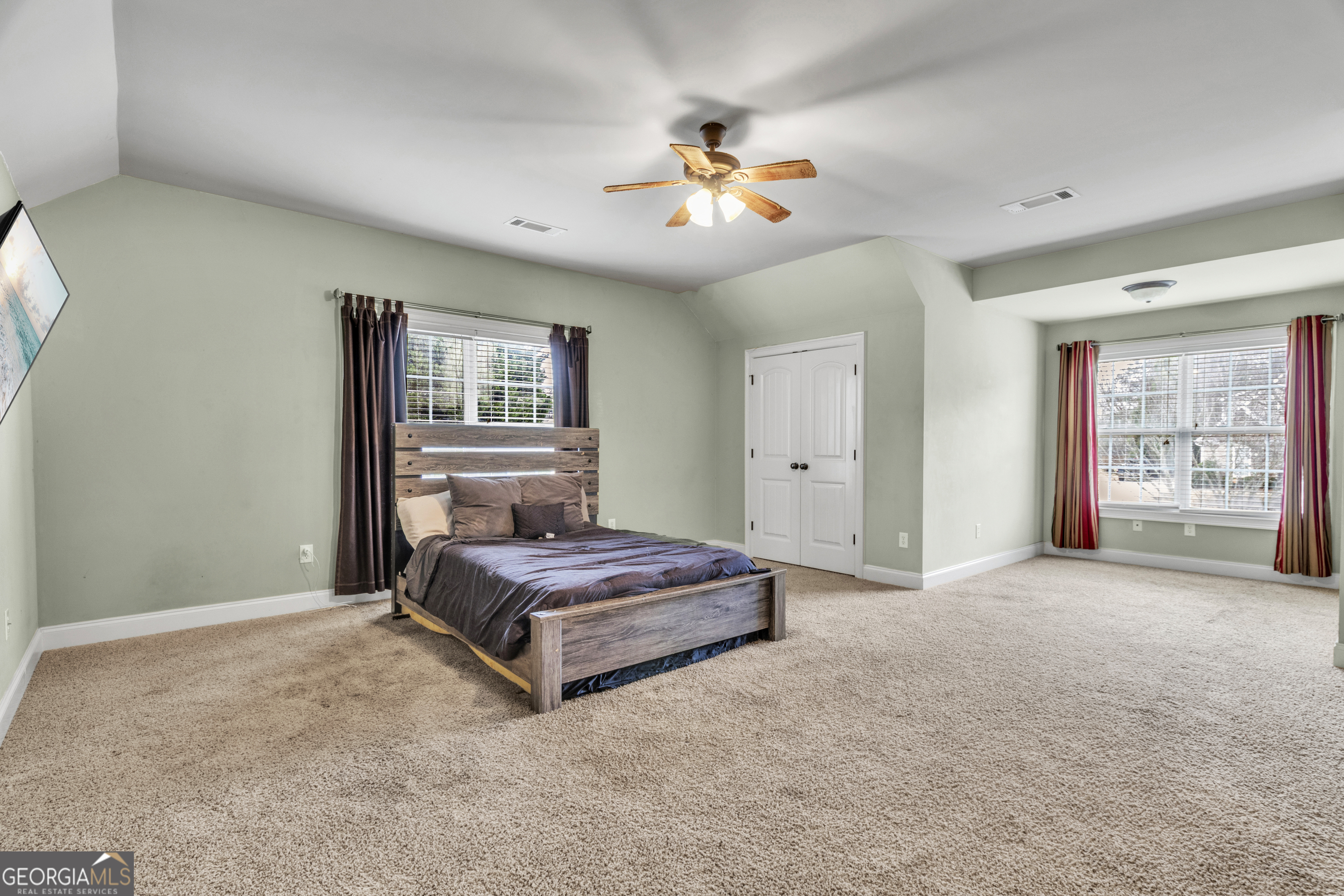 111 Caraway Road Locust Grove, GA 30248 - Photo 44 of 52 a spacious bedroom with a large bed and a chandelier