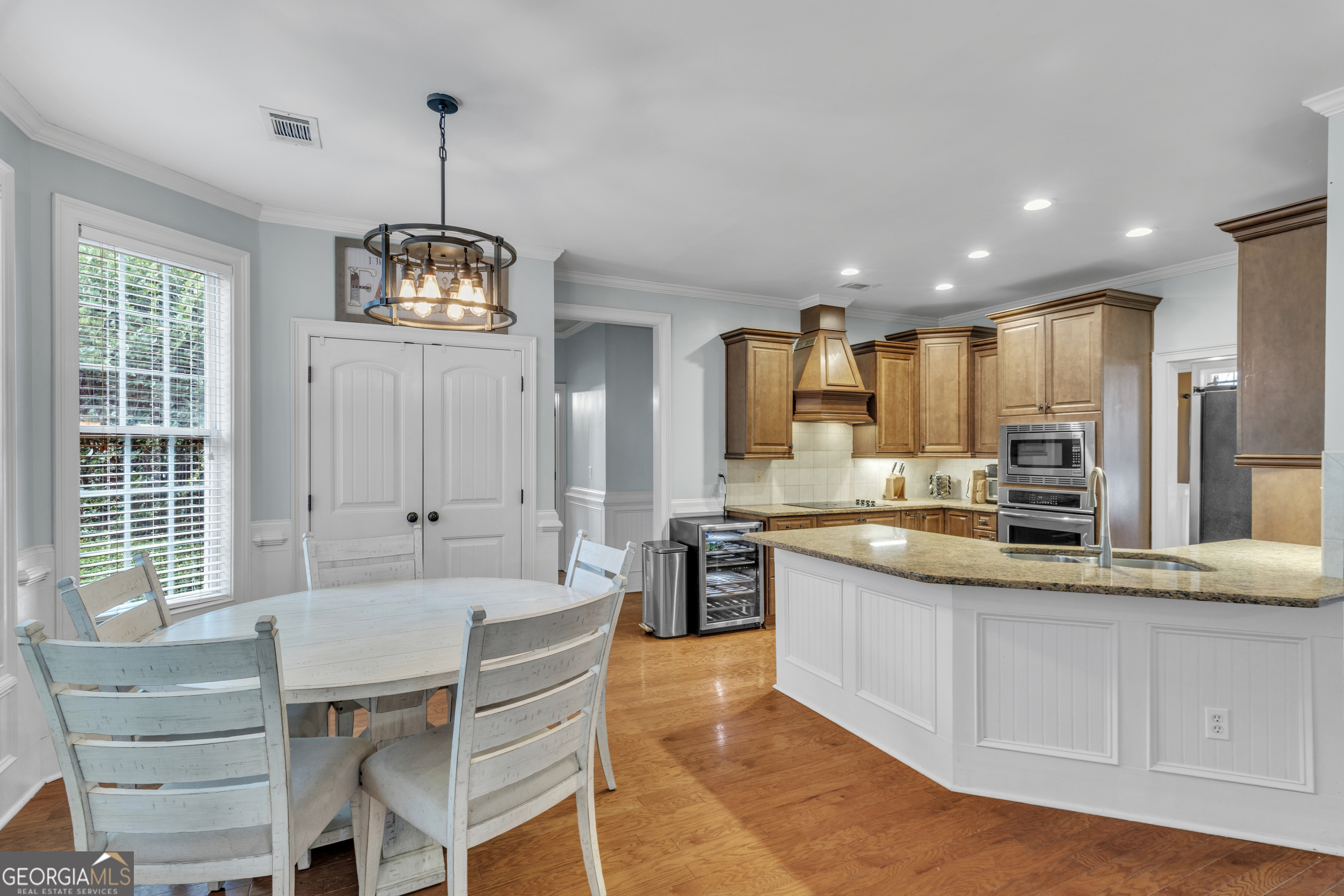 111 Caraway Road Locust Grove, GA 30248 - Photo 45 of 52 a large kitchen with kitchen island granite countertop a stove a sink a refrigerator and white cabinets next to a window