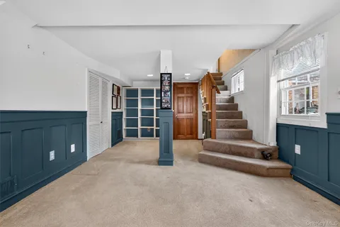 a view of an empty room with stairs and furniture