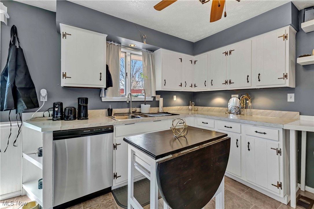 7760 York Road Cleveland, OH 44130 - Photo 6 of 39 Kitchen featuring a sink, stainless steel dishwasher, white cabinetry, light countertops, and ceiling fan