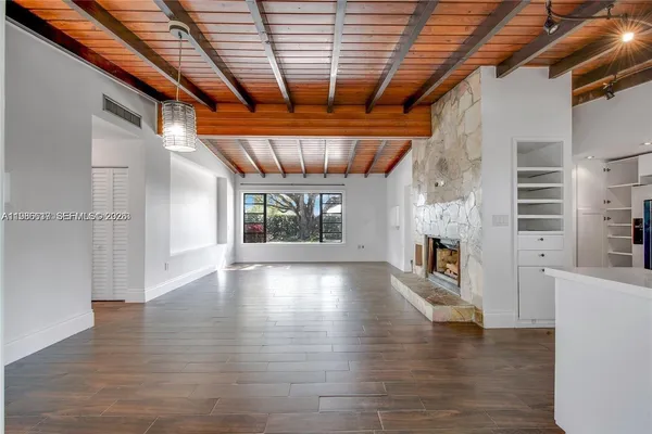 a view of empty room with wooden floor and a fireplace