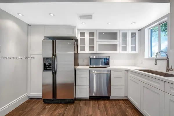 a kitchen with stainless steel appliances a refrigerator sink and cabinets