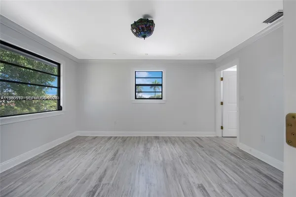 an empty room with wooden floor and window