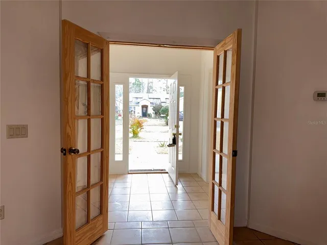 a view of a room that has a door and chandelier