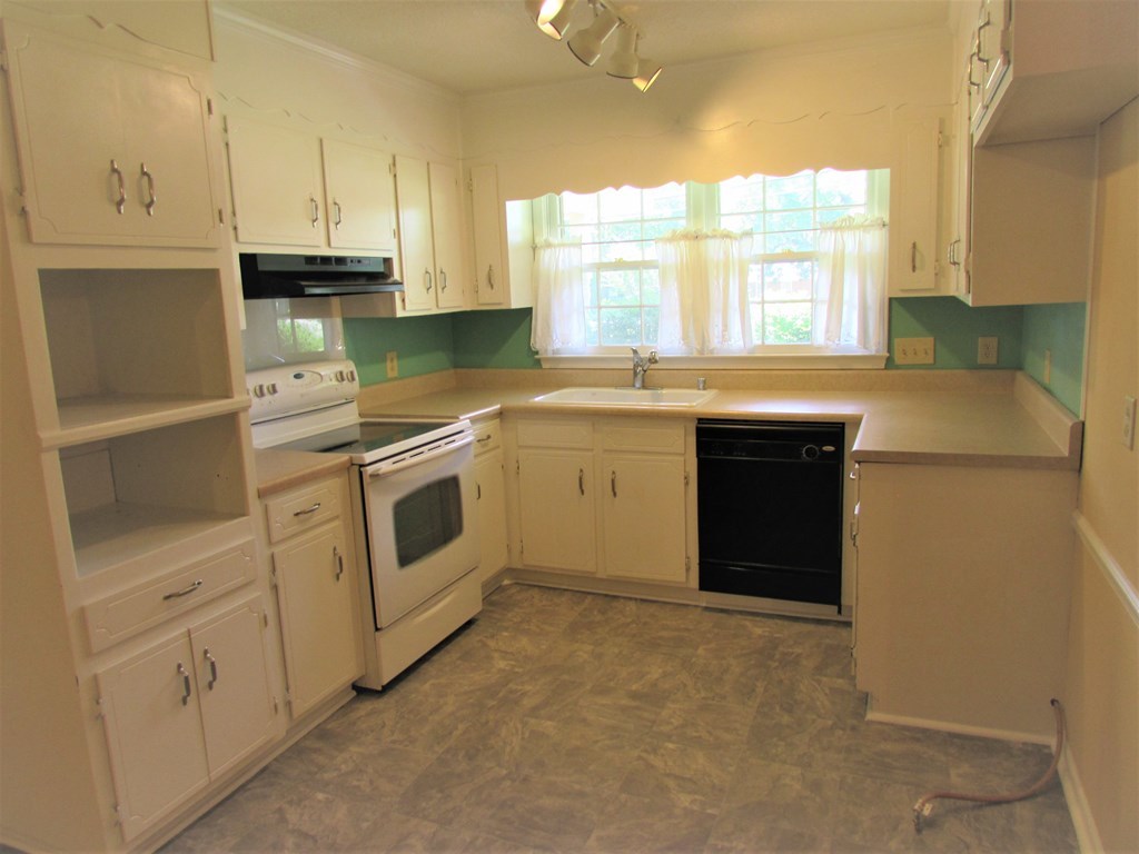 3847 Hartley Bridge Road Macon, GA 31216 - Photo 19 of 26 a kitchen with white cabinets and white appliances