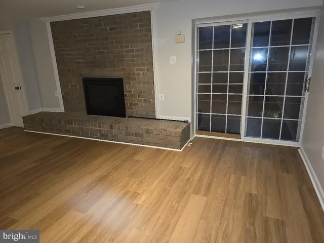 a view of empty room with wooden floor and fireplace