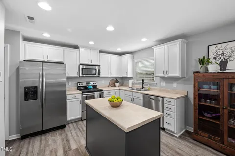a kitchen with a sink a microwave a refrigerator and cabinets