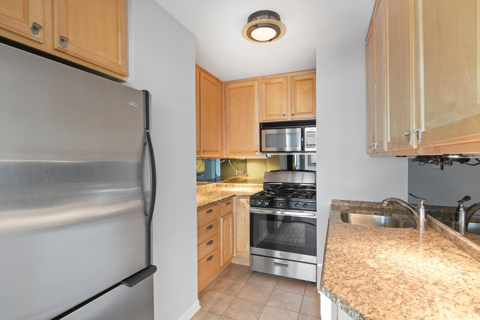 247 East Chestnut Street, Unit 1204 Chicago, IL 60611 - Photo 4 of 16 a kitchen with a stove and a refrigerator