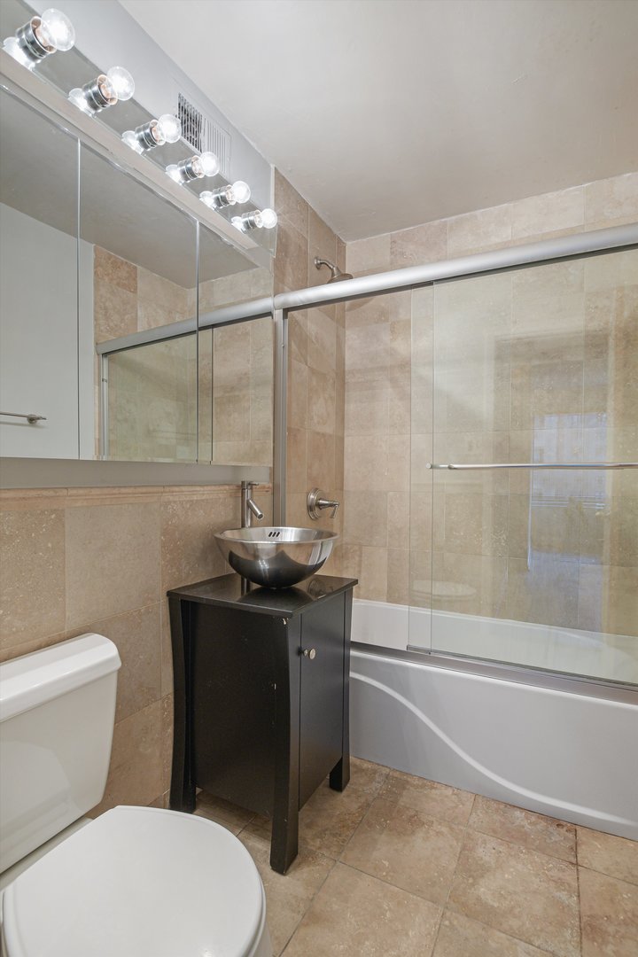 247 East Chestnut Street, Unit 1204 Chicago, IL 60611 - Photo 5 of 16 a bathroom with a sink a toilet and shower