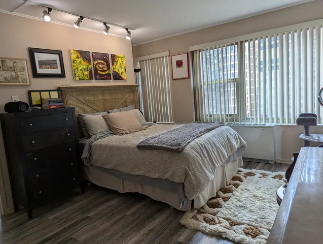 a bedroom with a bed and painting on the wall