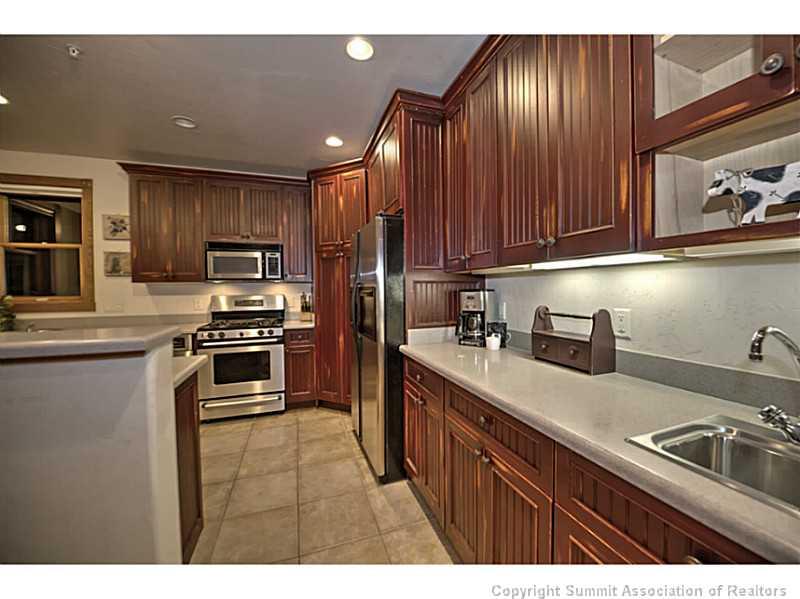 70 River Run Road, Unit 202 Keystone, CO 80435 - Photo 9 of 19 a kitchen with kitchen island a sink stainless steel appliances and cabinets