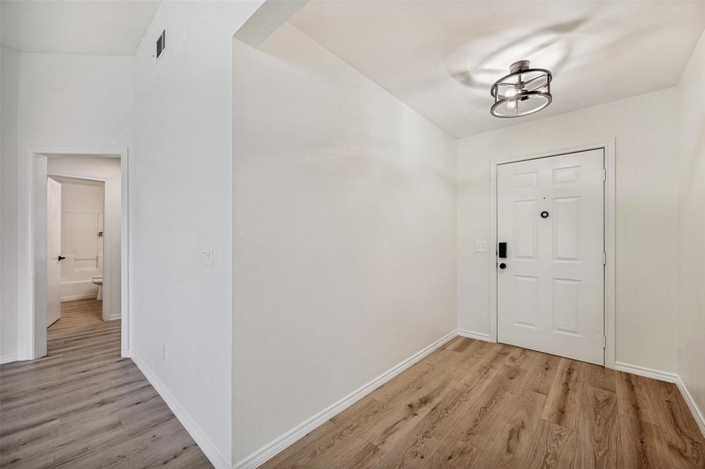 629 Concho Drive Oak Point, TX 75068 - Photo 15 of 35 a view of a hallway with wooden floor and a bathroom