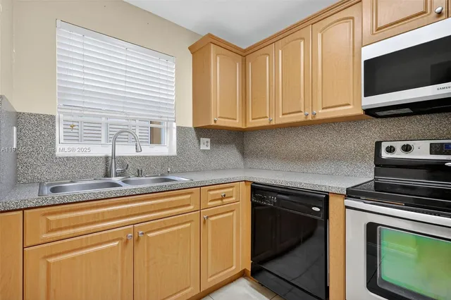 a kitchen with stainless steel appliances granite countertop a stove a microwave and cabinets