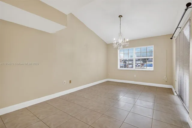 an empty room with windows and ceiling fan
