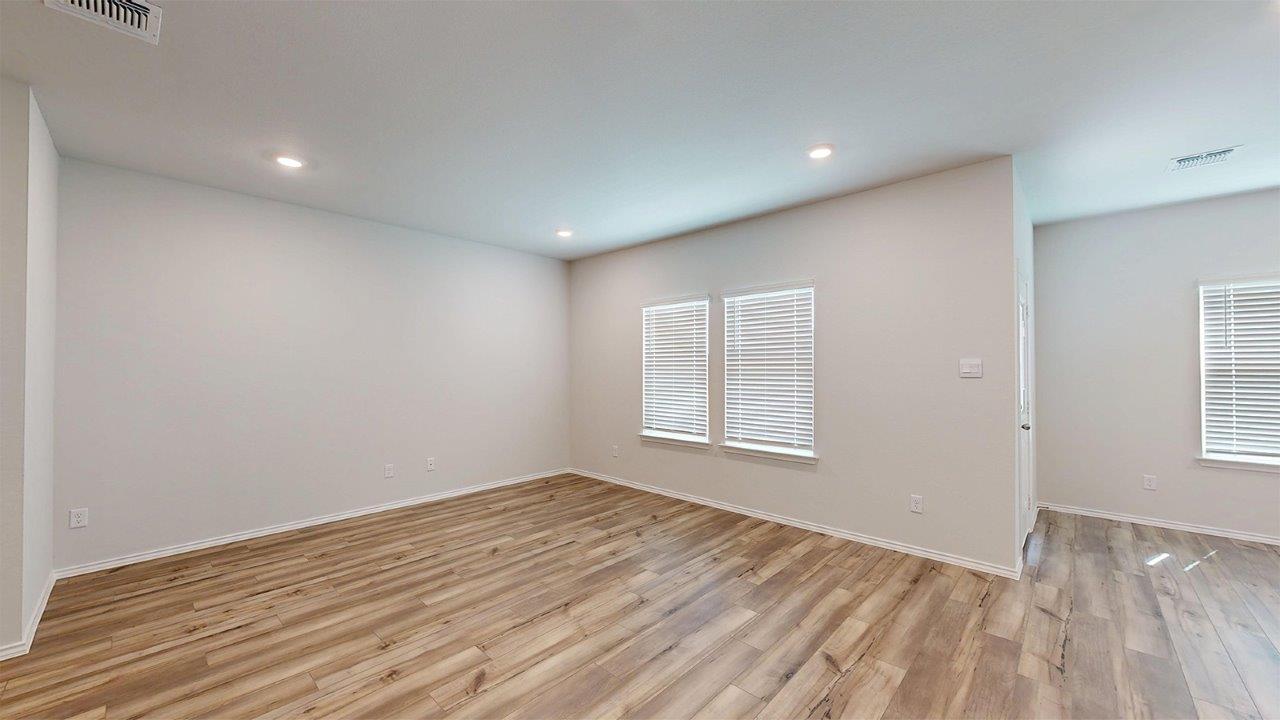 557 Hector Loop Georgetown, TX 78626 - Photo 14 of 38 Spacious interior featuring wood-finish flooring, recessed lighting, and multiple windows with blinds