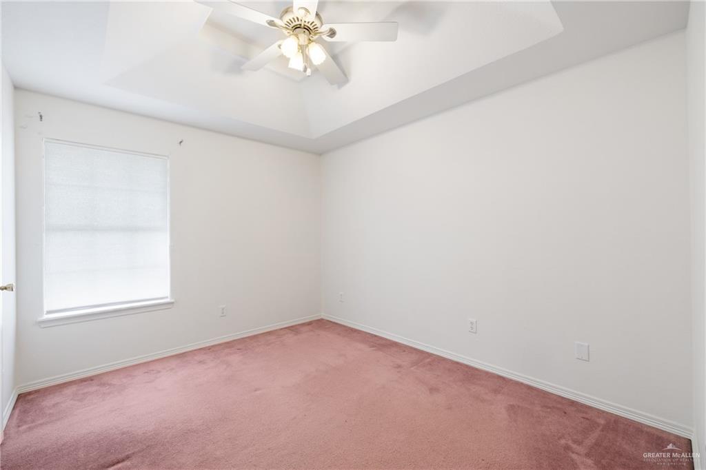 4822 East Canton Road Edinburg, TX 78542 - Photo 15 of 28 an empty room with a chandelier fan and windows