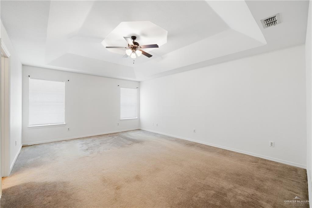 4822 East Canton Road Edinburg, TX 78542 - Photo 16 of 28 an empty room with a chandelier fan and windows