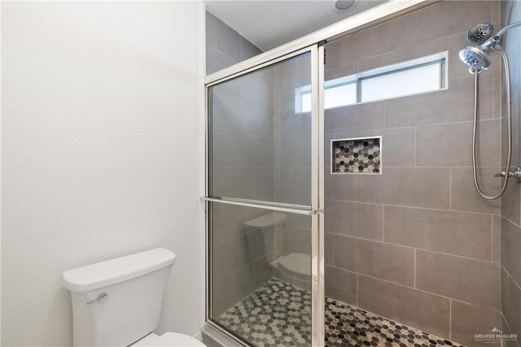 4822 East Canton Road Edinburg, TX 78542 - Photo 18 of 28 a bathroom with a shower and a toilet