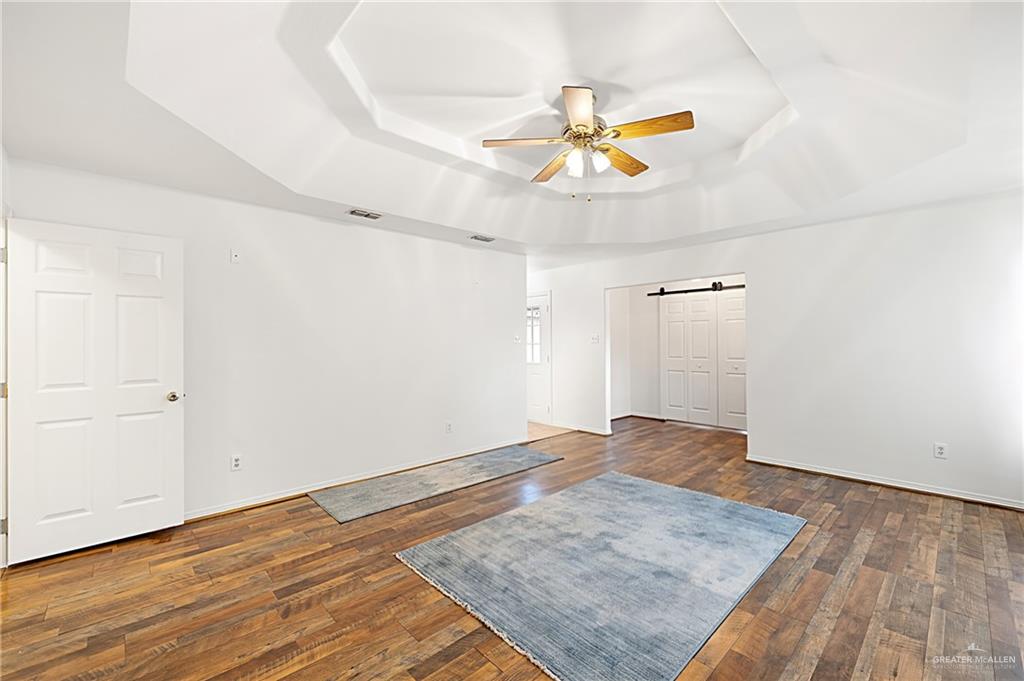 4822 East Canton Road Edinburg, TX 78542 - Photo 5 of 28 an empty room with wooden floor and windows